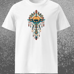 Könnte beinhalten: Weißes T-Shirt mit einem farbenfrohen Grafikdesign. Das Design zeigt eine Büffelsilhouette, Federn und geometrische Formen in Blau-, Orange- und Türkistönen. Der Text "Realm of Mythology" befindet sich unten.