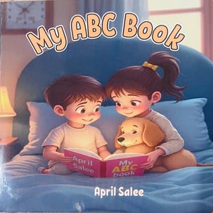 May include: A children's book titled "My ABC Book" featuring an illustration of two children and a dog reading together. The book cover is pink with the title and author's name, April Salee, displayed. The background is a blue bed.