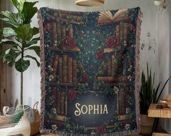 Peut inclure: Une couverture bleue foncée avec un motif de bibliothèque orné de livres, de roses et de vignes. Le nom "SOPHIA" est affiché en lettres claires. La couverture a une bordure à franges et est faite d'un matériau doux.