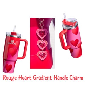 Könnte beinhalten: Ein rot-rosa Farbverlauf-Becher mit Griff und Strohhalm, verziert mit roten Herzen. Ein passender Griffanhänger mit drei Herzanhängern hängt in der Nähe. Der Text "Rouge Heart Gradient Handle Charm" befindet sich unten.