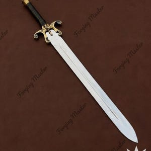 May include: A double-edged steel sword featuring a central fuller, a brass crossguard with ornate scrollwork and a central skull motif, and a black leather-wrapped grip with a brass pommel. The blade is polished and tapers to a sharp point.
