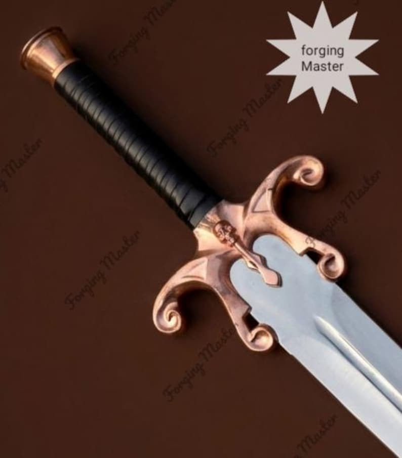 May include: A sword featuring a silver-toned blade, a black wrapped handle, and a copper-colored crossguard with a skull emblem. The crossguard has curved, scroll-like ends. The text Forging Master is visible on the blade and background.