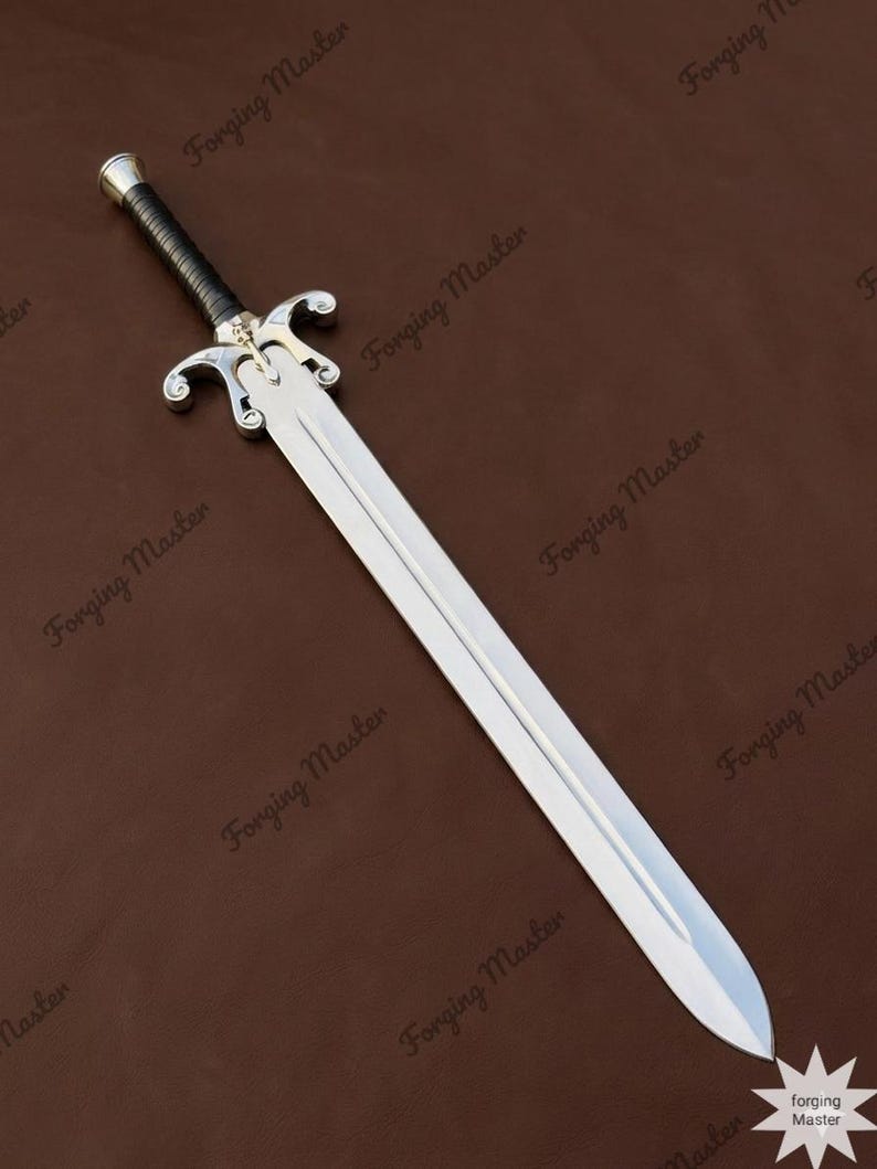 May include: A silver-colored metal sword with a double-edged blade and a central fuller. The hilt features a black wrapped grip, a metallic pommel, and a decorative crossguard with curved ends. The text Forging Master appears repeatedly.