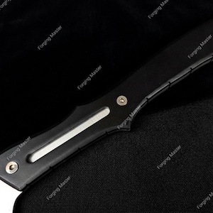 Puede incluir: Primer plano de un cuchillo negro y plateado. El cuchillo tiene una hoja curva y un mango negro con detalles plateados. El texto "Forging Master" est&aacute; impreso en el mango.