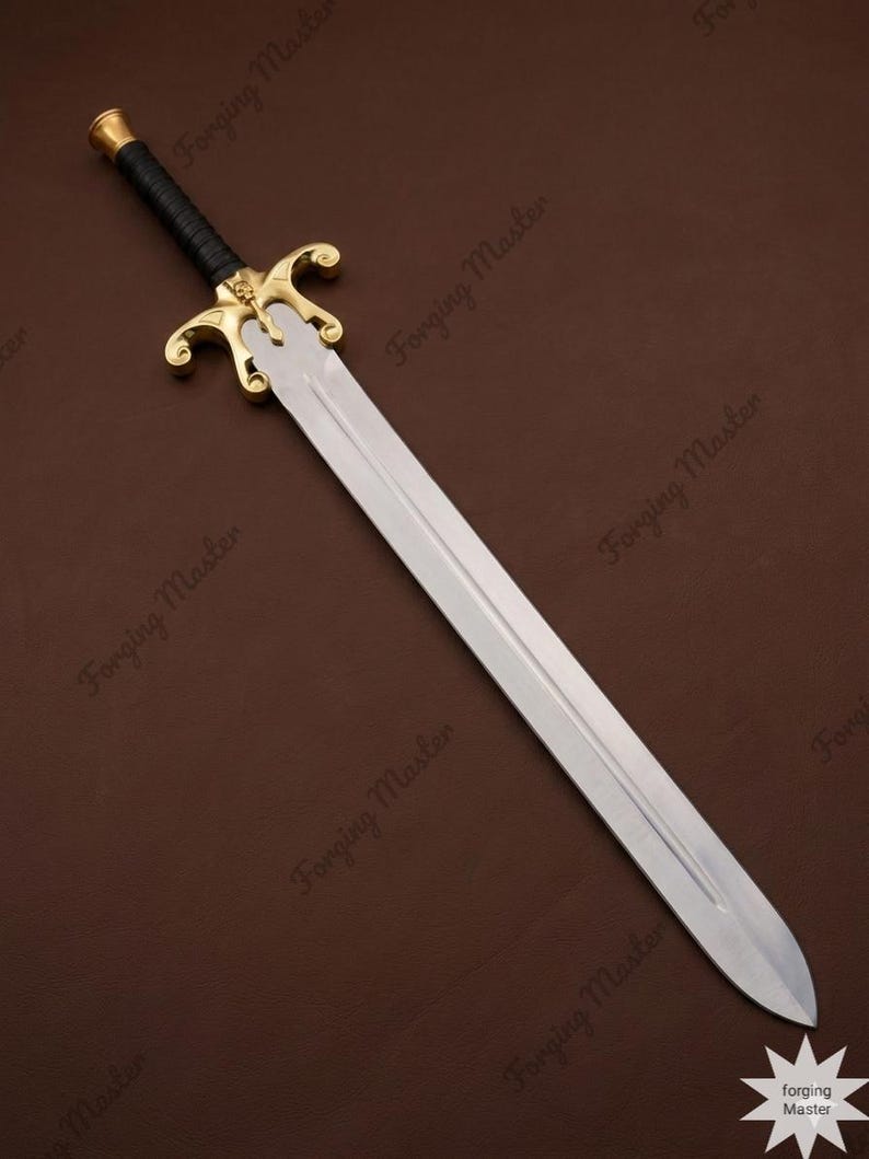 May include: A sword with a double-edged steel blade, a gold-colored metal crossguard featuring a central skull emblem, and a black wrapped handle with a gold-colored pommel. The blade has a central fuller, and the text Forging Master is visible.