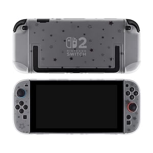 May include: A gray Nintendo Switch console with a clear protective case. The case is decorated with small black star shapes. The console has black buttons and a black screen. The Nintendo Switch logo is visible on the back of the console.