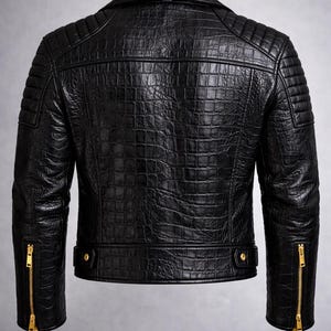 May include: Black leather jacket with a textured, crocodile-like pattern. Features a classic collar, quilted shoulder detailing, and gold-toned zippers on the sleeves. The jacket has a tailored fit and a sleek, modern design.