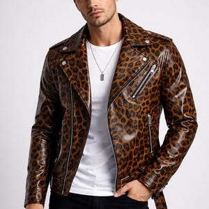 Könnte beinhalten: Eine braun-schwarze Lederjacke mit Leopardenmuster, einem Reverskragen, asymmetrischem Reißverschluss und einem Gürtel in der Taille. Die Jacke wird über einem weißen T-Shirt und einer schwarzen Hose getragen.