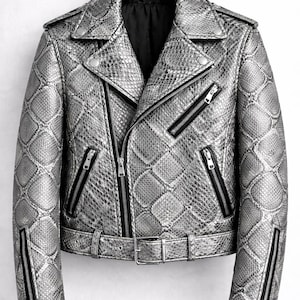 May include: Silver faux snakeskin biker jacket with black zippers and a belt. The jacket has a classic asymmetrical zip closure, notched lapels, and a quilted design on the shoulders.
