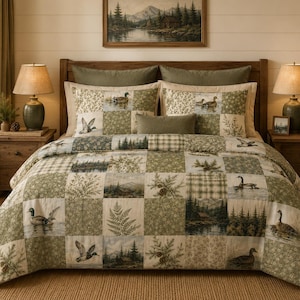 May include: A patchwork quilt and matching pillow shams featuring a repeating pattern of ducks, pine trees, mountain landscapes, ferns, and plaid squares in shades of sage green, cream, and brown, displayed on a bed with two lamps.