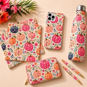 May include: A collection of items featuring a floral pumpkin pattern including a stack of square notebooks, a smartphone case, a metal water bottle with a silver cap, a zippered rectangular wallet, and two ballpoint pens, all with matching designs.