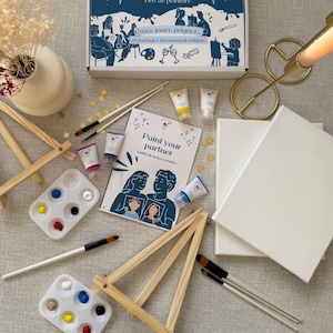 Könnte beinhalten: Ein Mal-dich-selbst-Set mit einer blauen Box mit der Aufschrift "Box de peinture". Das Set enthält Farbtuben, Pinsel, Staffeleien, Farbpaletten und Leinwände. Das Set enthält auch ein Heft mit dem Titel "Paint your partner".