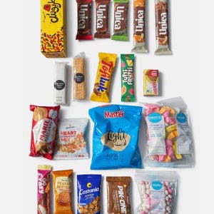 May include: A selection of packaged snacks, including chocolate bars, biscuits, and crisps. The image showcases a variety of brands and flavours, with a focus on colourful packaging and product diversity. A blue bag reads "Master Light".
