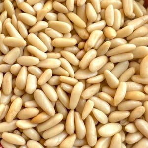 Könnte beinhalten: Nahaufnahme eines Haufens Pinienkerne. Die Nüsse sind oval geformt und haben eine cremefarbene Beige. Sie sind dicht gepackt und füllen den Rahmen aus. Die Textur erscheint glatt und leicht glänzend, was auf Frische hindeutet.