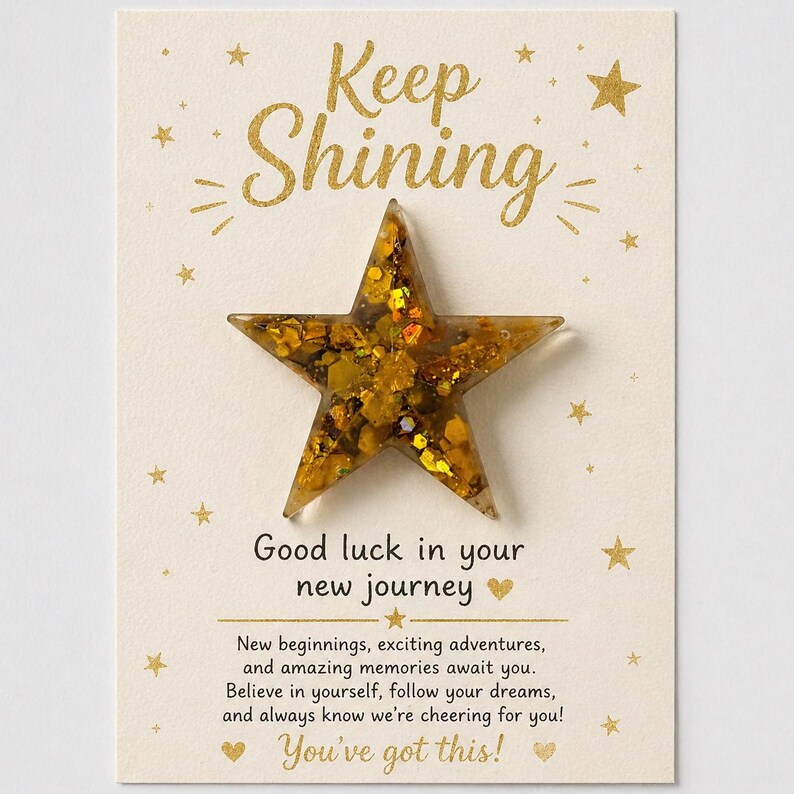 May include: A greeting card with a gold star and the words "Keep Shining" in gold script. The card also includes the text "Good luck in your new journey" and "You've got this!" with additional supportive text.