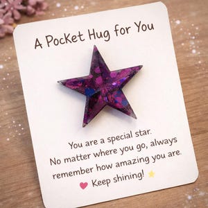 May include: A Pocket Hug for You card with a purple star-shaped charm. The star is filled with glitter and blue accents. The card has text that reads, "You are a special star. Keep shining!"
