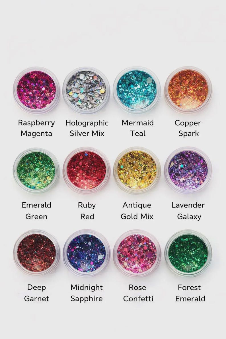 May include: A collection of twelve small, clear jars filled with colorful glitter. Each jar is labeled with a color name, including Raspberry Magenta, Mermaid Teal, and Forest Emerald. The glitter colors range from pinks and blues to greens and golds.