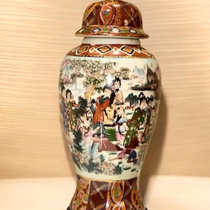 Può includere: Un barattolo di zenzero decorativo in porcellana con coperchio, caratterizzato da una scena dipinta a mano di figure in un paesaggio. Il barattolo ha un corpo color crema con intricati motivi rossi, dorati e multicolori sul collo e sulla base, sormontato da un pomello dorato.