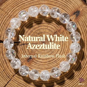 May include: A bracelet made of clear, round Azeztulite beads. The beads have internal rainbow flashes and are strung together. The text on the image reads "Natural White Azeztulite" and "Internal Rainbow Flash".