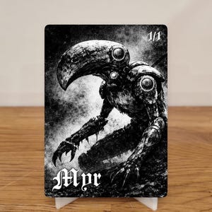 Könnte beinhalten: Schwarz-weiß Fantasy-Art-Karte mit einem Wesen mit vogelähnlichem Kopf und mechanischen Gliedmaßen. Die Karte ist mit "1/1" und "Mpr" beschriftet. Die Karte wird auf einem weißen Ständer präsentiert.