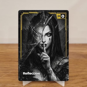 Op de afbeelding: Een zwarte en gouden kaart met een vrouw met donker haar die haar vinger voor haar lippen houdt. De kaart heeft het woord "Reflection" en het nummer "0". De kaart staat op een witte standaard. De afbeelding heeft een donkere esthetiek.