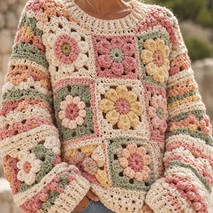 Puede incluir: Un suéter de manga larga confeccionado con cuadrados de ganchillo que presentan un motivo floral. La prenda muestra una paleta de colores crema, rosa suave, verde salvia y amarillo pálido, con cuello y puños acanalados en hilo crema liso.