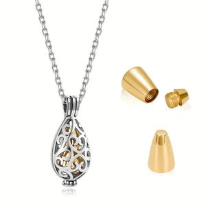 Può includere: Una collana con pendente a goccia color argento con un design a filigrana aperta, che rivela un interno color oro. La collana include una catena abbinata e un'urna color oro separata con un tappo a vite, progettata per contenere una piccola quantità di resti cremati.