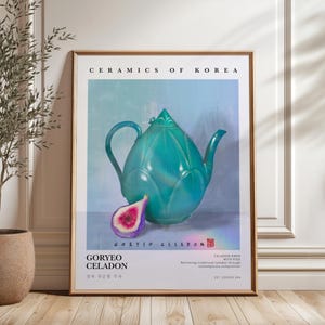 May include: A framed art print featuring a teal ceramic teapot and a sliced fig. The artwork, titled "Ceramics of Korea," includes text in English and Korean, showcasing the Goryeo Celadon style. The teapot has a unique, stylized design.
