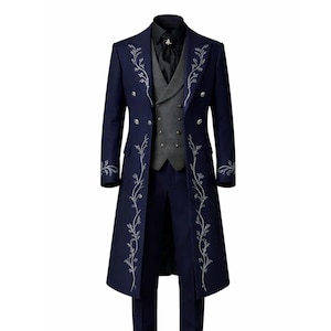 May include: A navy blue formal suit with a long coat, silver floral embroidery, a grey waistcoat, and matching trousers. The outfit includes a black shirt and tie, creating a sophisticated ensemble.
