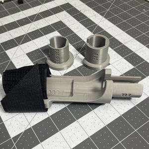 May include: A selection of grey 3D-printed components. Two cylindrical pieces are labelled "30.9/31.6" and "34.9", and a larger, rectangular part has "22.2" printed on it. A black fabric piece is attached.