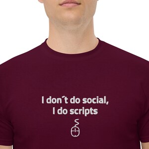 Puede incluir: Camiseta granate con texto blanco: "I don't do social, I do scripts" y un pequeño icono de ratón. La camiseta es de material suave y tiene cuello redondo.