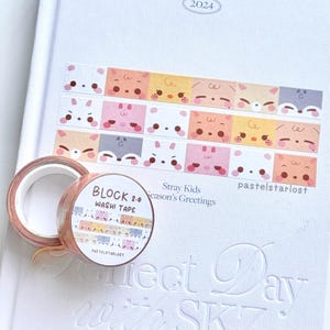 Puede incluir: Un rollo de cinta washi con un patrón repetido de caras de animales de dibujos animados en colores pastel. La cinta está etiquetada como "BLOCK 2.0 WASHI TAPE" y "pastelstarlost". También se muestra una hoja de cinta washi con el mismo diseño.