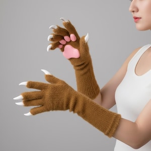 May include: Brown, furry gloves with white claws and a pink paw pad. The gloves are designed to resemble animal paws. The gloves are long, covering the wrist and part of the forearm.