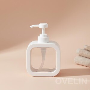 Puede incluir: Un dispensador de jabón blanco, de forma cuadrada, con interior transparente y bomba blanca. El dispensador tiene esquinas redondeadas y un diseño minimalista. La palabra "OVELIN" está impresa en la esquina inferior derecha.
