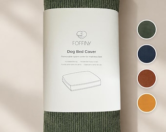 Può includere: Una fodera per cuccia in velluto a coste verde oliva arrotolata con una fascia di carta bianca che riporta il logo Foffiny, il testo Dog Bed Cover e un disegno al tratto di un materasso. A destra ci sono quattro campioni di colore circolari.