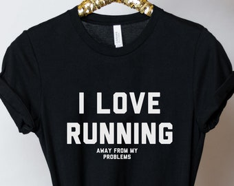 May include: Black t-shirt with white text that reads "I love running away from my problems".