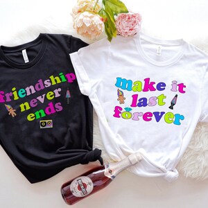 May include: Two black and white t-shirts with colorful text and graphics. The black shirt says "friendship never ends" and the white shirt says "make it last forever".