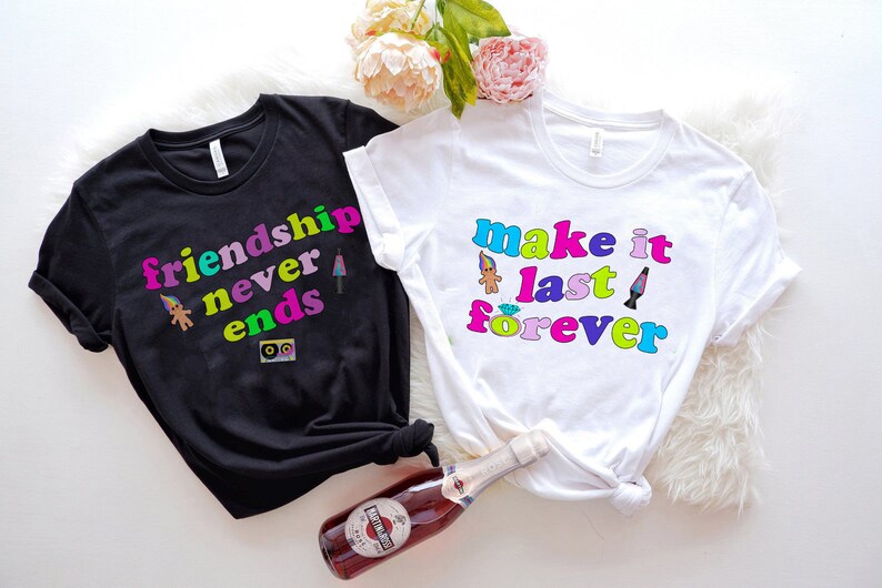 May include: Two black and white t-shirts with colorful text and graphics. The black shirt says "friendship never ends" and the white shirt says "make it last forever".
