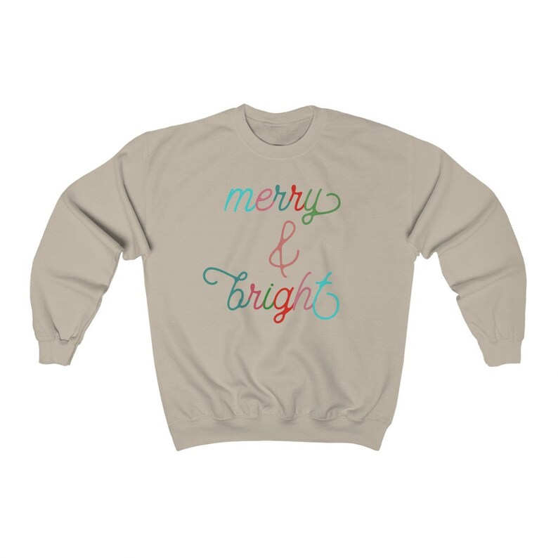 May include: A light beige sweatshirt with the text "merry & bright" in colourful script.