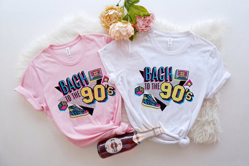May include: Two white t-shirts with a pink and white graphic design that says "Back to the 90's" with a cassette tape, a star, and a sneaker.