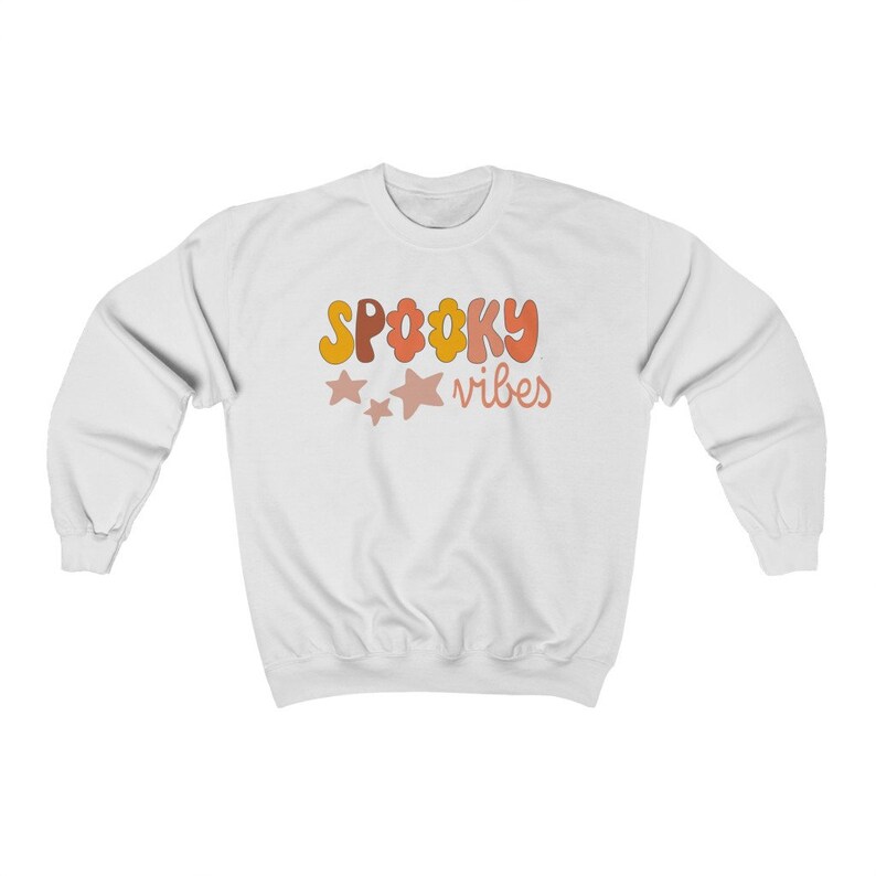 May include: White sweatshirt with the text "SPOOKY vibes" in orange, yellow, and pink letters with two pink stars.