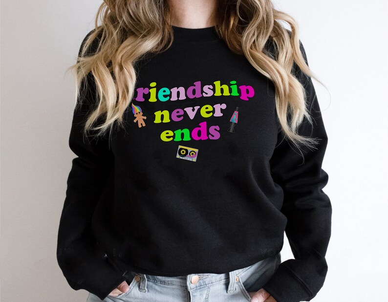 May include: Black sweatshirt with the text "Friendship never ends" in rainbow colors. The text is surrounded by small graphic images of a troll doll, a cassette tape, and a lava lamp.