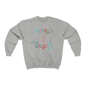 May include: A grey sweatshirt with the text "merry & bright" in colourful script.