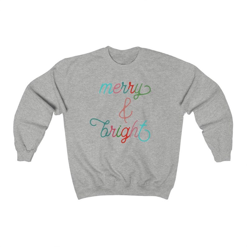 May include: A grey sweatshirt with the text "merry & bright" in colourful script.