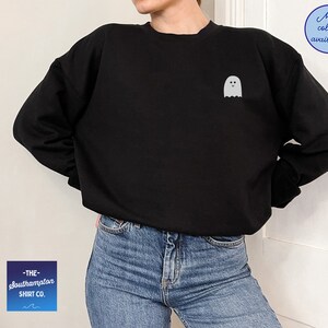 May include: Black sweatshirt with a white ghost graphic on the front. The text "THE southampton SHIRT CO." is on a blue and white gradient background.