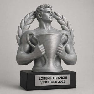 Op de afbeelding: Een zilverkleurige trofee met een gespierd figuur dat een grote beker vasthoudt, omlijst door laurierbladeren. De trofee staat op een zwarte rechthoekige voet met een zilveren plaatje met de tekst: LORENZO BIANCHI VINCITORE 2026. Het ontwerp is gedetailleerd.