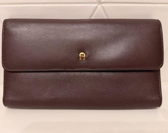 Carteira porta-cheques de couro marrom Etienne Aigner, estilo vintage, com duas dobras.