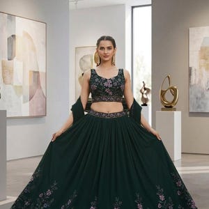 以下が含まれることがあります： ダークグリーンのフォーマルドレス。ノースリーブのトップスとロングスカートのセットで、花柄の刺繍が施されています。特別な機会にふさわしい、エレガントなドレスです。