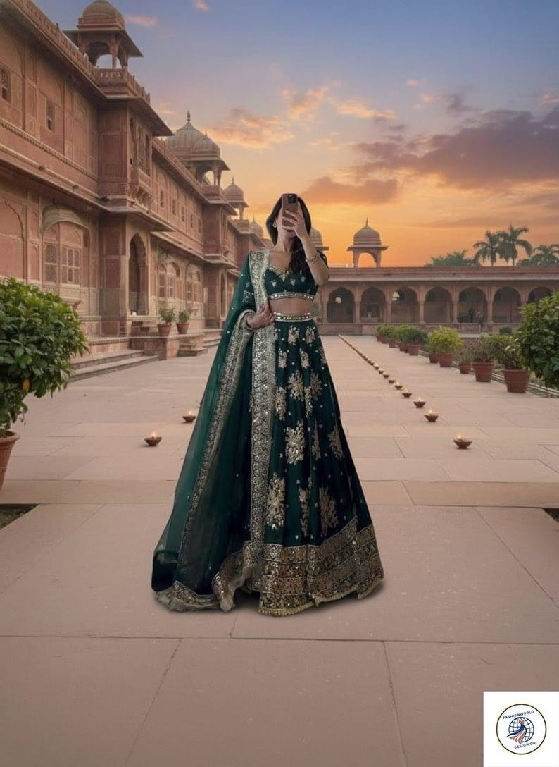 Może przedstawiać: Ciemnozielona lehenga ze złotym haftem. Str&oacute;j zawiera pasujący dupatta i kr&oacute;tki top. Lehenga ma skomplikowane złote detale wzdłuż obszycia i obramowań. Tło przedstawia zach&oacute;d słońca i budynek z łukami.