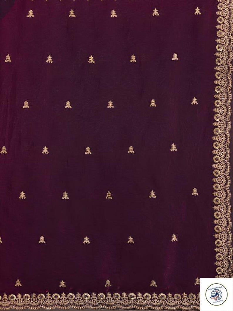 Peut inclure: Un textile bordeaux profond avec des broderies dor&eacute;es complexes. Le tissu pr&eacute;sente un motif r&eacute;p&eacute;t&eacute; de petits motifs floraux dor&eacute;s orn&eacute;s. Une bordure dor&eacute;e d&eacute;taill&eacute;e longe le bord, ajoutant une touche d'&eacute;l&eacute;gance. Le design sugg&egrave;re un v&ecirc;tement luxueux ou une pi&egrave;ce d&eacute;corative.